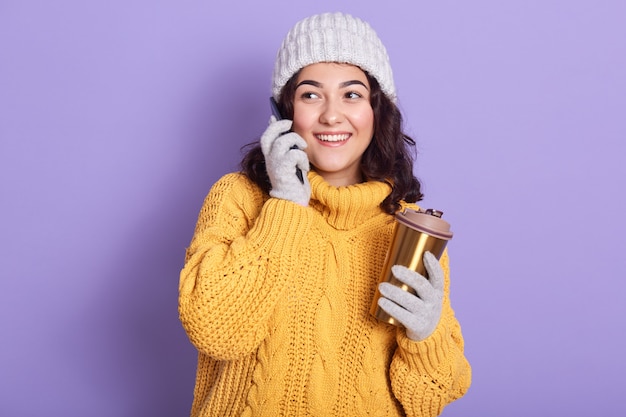 Belle jeune femme souriante de côté, isolée sur lilas