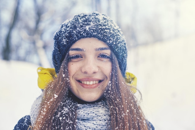 Belle jeune femme souriante à l'extérieur en hiver