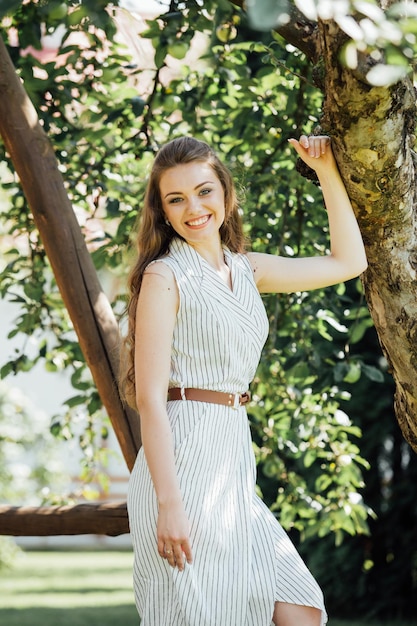 Une belle jeune femme souriante à l'extérieur.