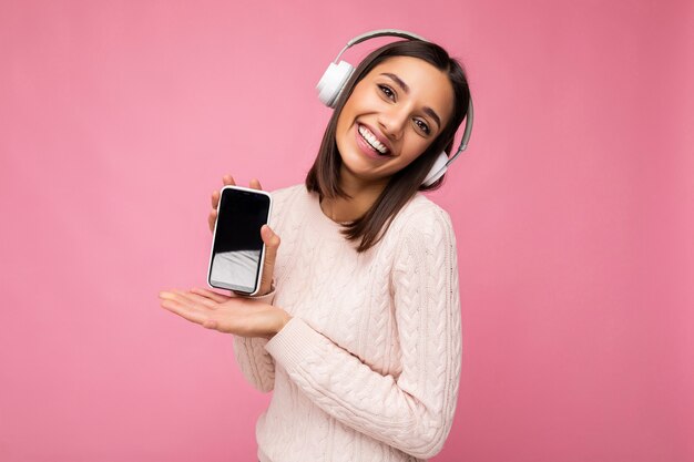 Belle jeune femme souriante heureuse portant une tenue décontractée élégante isolée sur le mur de fond