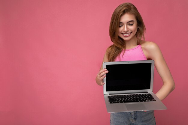 Belle jeune femme souriante et heureuse tenant un ordinateur portable regardant un netbook s'amusant