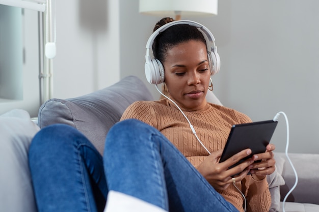 Belle jeune femme souriante et regardant une tablette