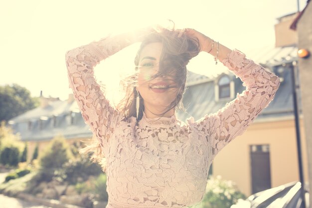 Belle jeune femme souriante en robe de dentelle vous regarde. Effet tonifiant vintage