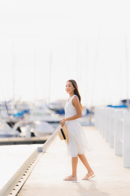 Photo une belle jeune femme souriante se tient au port.