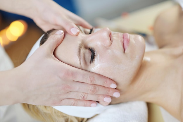 Belle jeune femme en spa et bien-être. Massage du visage et du dos aux pierres