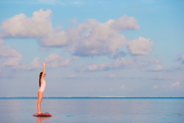 Belle jeune femme surfer sur stand up paddle en vacances exotiques