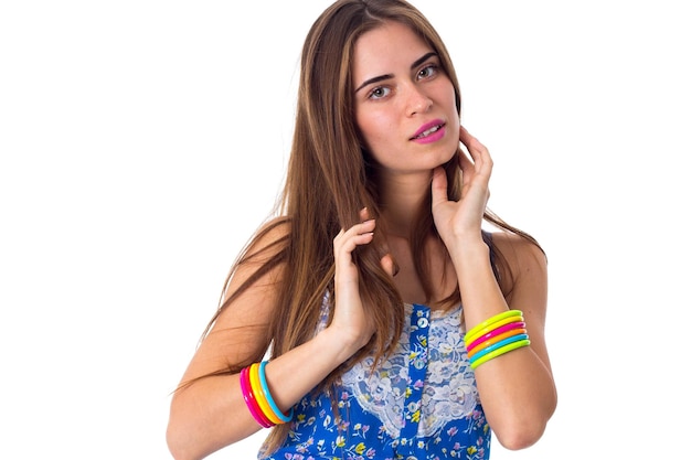 Belle jeune femme en T-shirt bleu et blanc avec des bracelets multicolores touchant ses cheveux