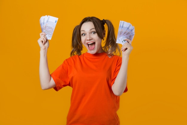 belle jeune femme en t-shirt avec euro en mains