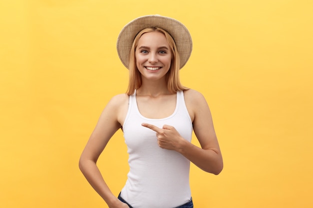 Belle jeune femme en t-shirt pointant vers l'extérieur avec le doigt