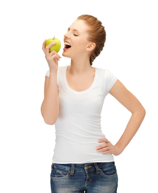 belle jeune femme en t-shirt vierge mangeant une pomme verte