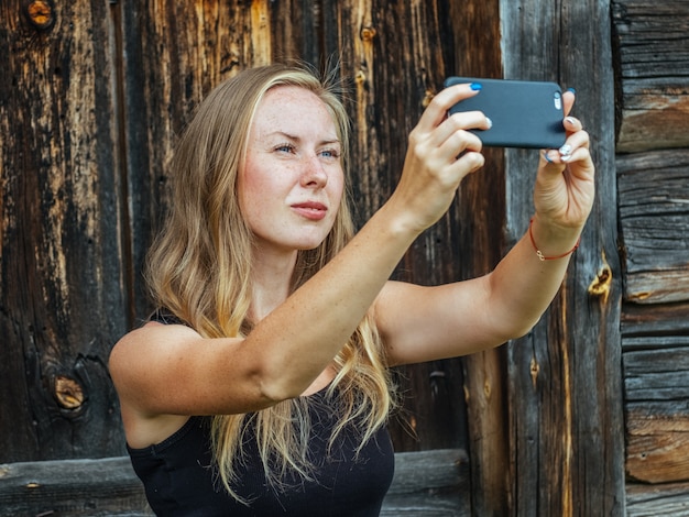 Belle jeune femme avec des taches de rousseur à l'aide de téléphone