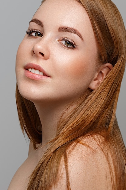 belle jeune femme avec des taches de rousseur portrait hipster studio posant. Sur fond gris