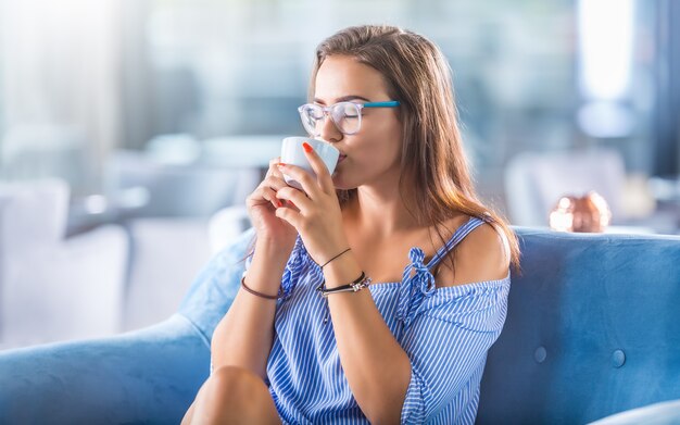 Belle jeune femme avec une tasse de café ou de thé au café.