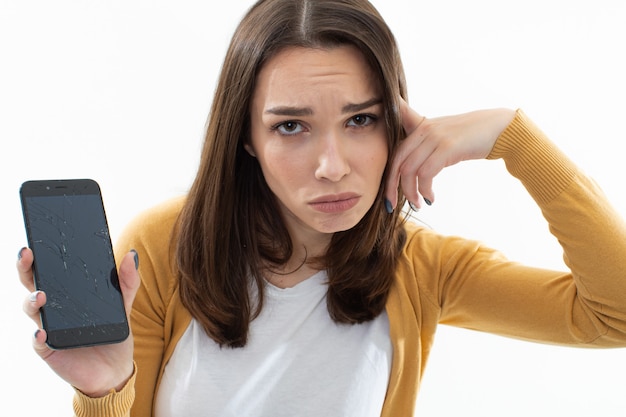 Belle jeune femme avec un téléphone cassé