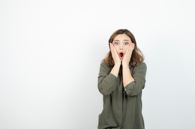 Belle jeune femme en tenue décontractée debout sur un mur blanc. Photo de haute qualité