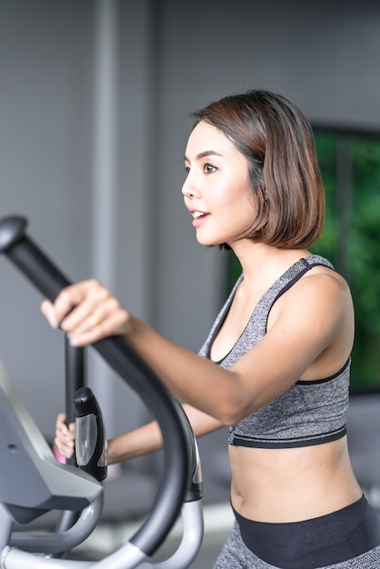 Belle jeune femme en tenue de sport dans la salle de sport