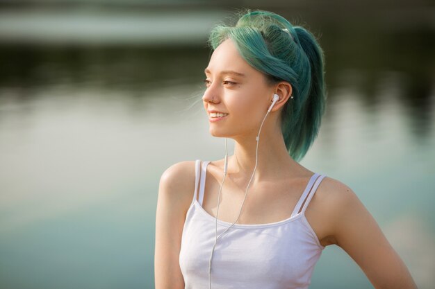 Belle jeune femme en tenue de sport, faire du yoga près du lac