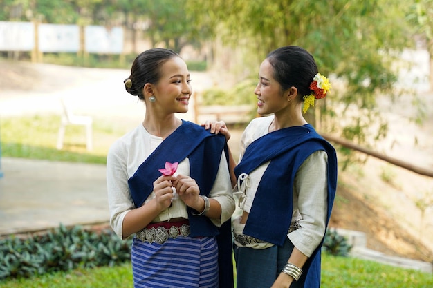 Belle jeune femme thaïlandaise ware robe traditionnelle du nord thaïlandais bavardant et taquinant les uns les autres