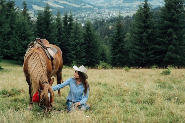 belle jeune femme tient un cheval dans les montagnes lors d'un voyage. espace de copie pour écrire du texte