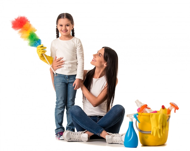 Belle jeune femme tient des détergents et un plumeau