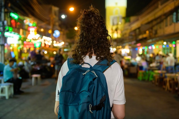 Belle jeune femme touriste asiatique en vacances visiter et explorer la route de Khao San la nuit