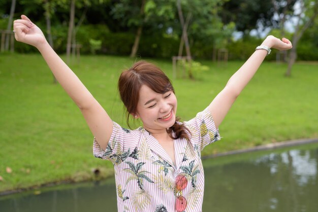 Belle jeune femme touristique asiatique se détendre dans le parc