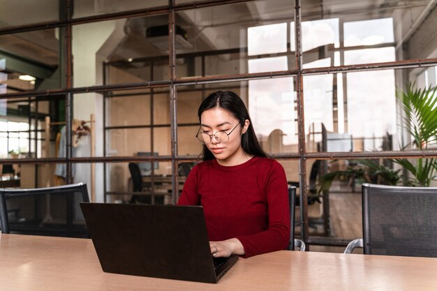 Belle jeune femme travaillant au bureau sur l'ordinateur portable.