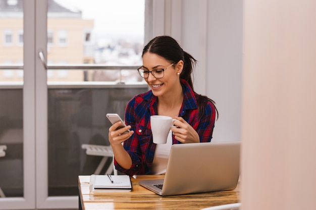 Belle jeune femme travaillant à la maison