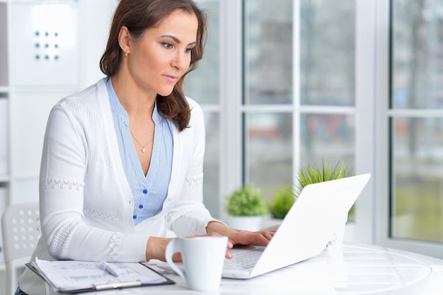 Belle jeune femme travaillant avec un ordinateur portable