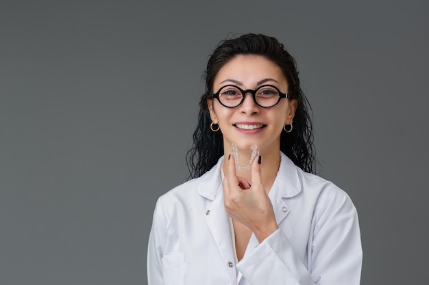 Belle jeune femme turque souriante tient un invisaligner