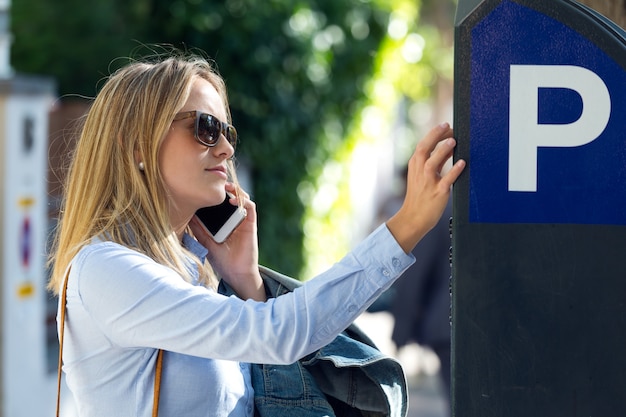 Belle jeune femme utilisant son téléphone mobile dans la rue.