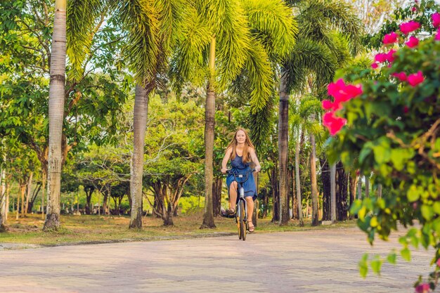 Belle jeune femme à vélo dans un parc personnes actives en plein air