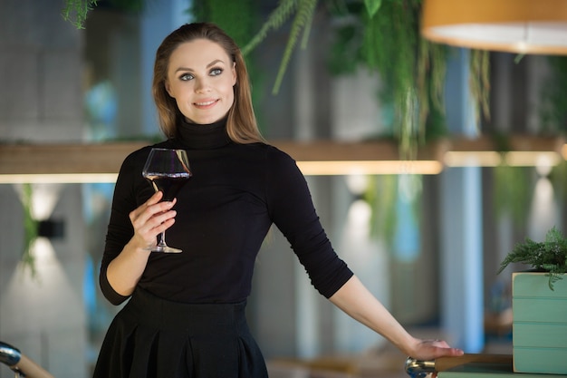 belle jeune femme avec un verre de vin dans un restaurant