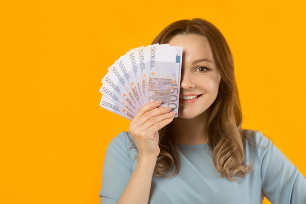 belle jeune femme vêtue d'une robe avec euro en mains