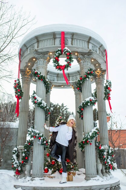 Photo belle jeune fille adulte joyeuse et heureuse dans un beau belvédère en décorations de noël