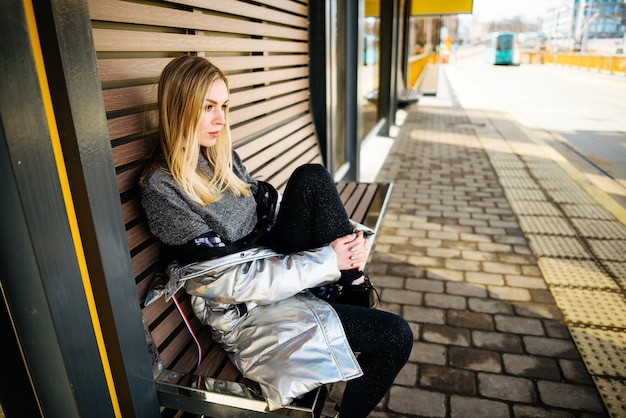 Belle jeune fille assise sur un banc