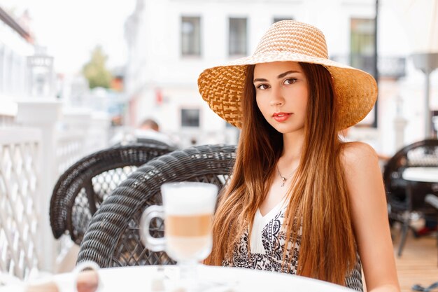 Belle jeune fille au repos dans un café d'été