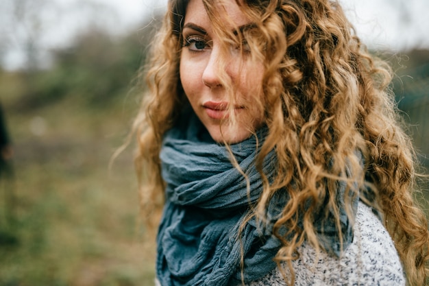 Belle jeune fille aux cheveux bouclés à l'extérieur