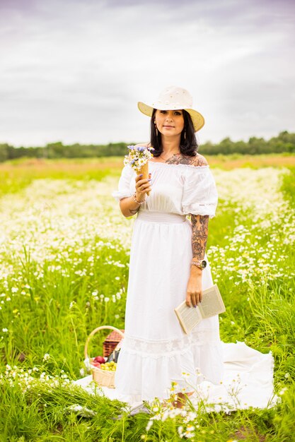 Belle jeune fille aux cheveux roux bouclés dans le champ de camomille