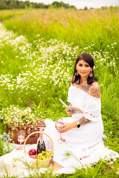 Belle jeune fille aux cheveux roux bouclés dans le champ de camomille