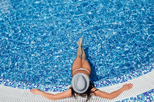 Une belle jeune fille avec une belle silhouette en maillot de bain blanc