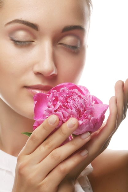 Belle jeune fille en bonne santé avec une fleur rose sur blanc