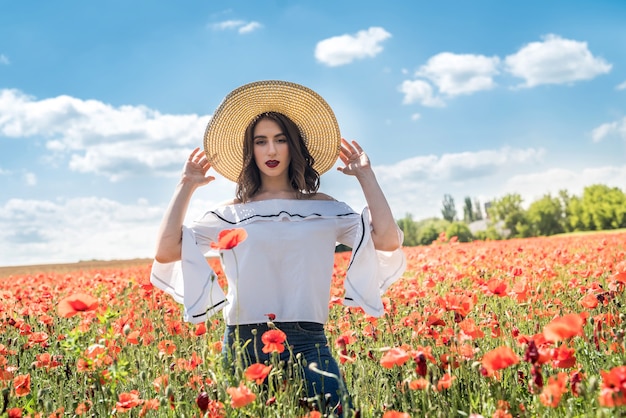 Belle jeune fille dans le champ de pavot. Elle passe du temps libre et du beau temps pour profiter