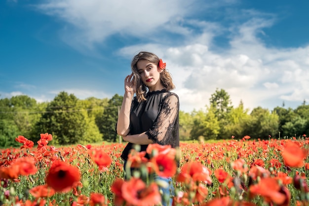 Belle jeune fille dans le champ de pavot