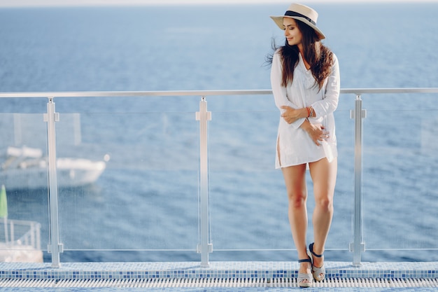 Une belle jeune fille debout sur une terrasse d&#39;été et en regardant l&#39;océan