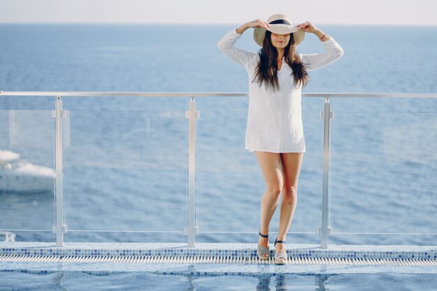 Une belle jeune fille debout sur une terrasse d&#39;été et en regardant l&#39;océan