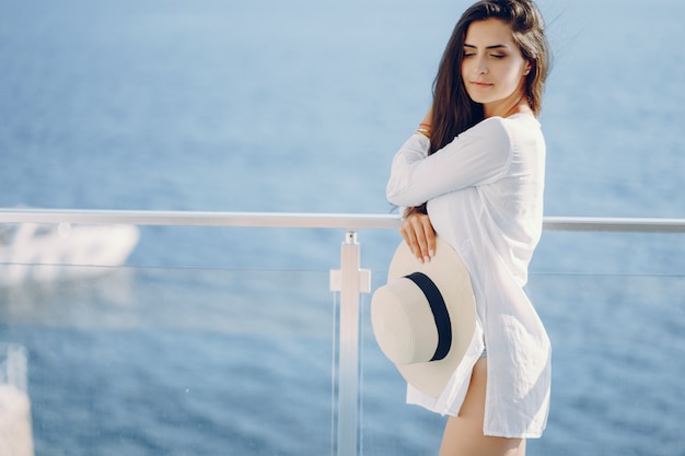 Une belle jeune fille debout sur une terrasse d&#39;été et en regardant l&#39;océan