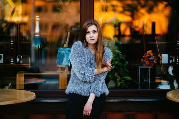 Belle jeune fille devant un café