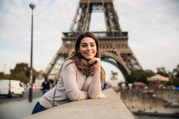 Belle jeune fille devant la tour eiffel fille sourit et se réjouit de la photo d'automne