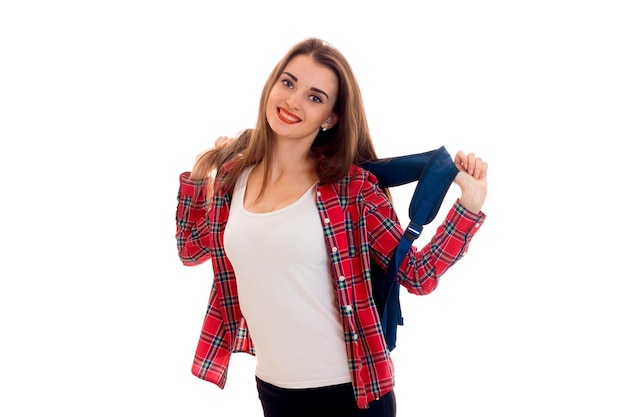 Belle jeune fille étudiante brune avec sac à dos bleu isolé sur fond blanc